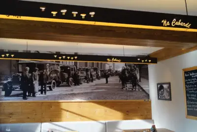 Restaurace s podsvíceným nápisem a dobovou fotografií