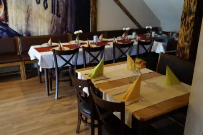 Prostřené stoly v salonku se žlutými ubrousky
